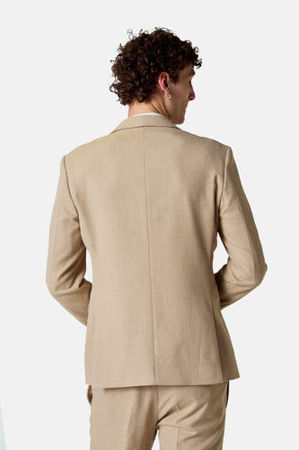 Blazer beige de Le Fabuleux Marcel de Bruxelles, avec un motif de tissage subtil, vu de derrière.