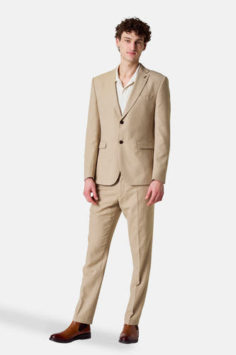 Pantalon costumier beige de Le Fabuleux Marcel de Bruxelles, porté avec des bottes Chelsea brunes et une chemise crème.