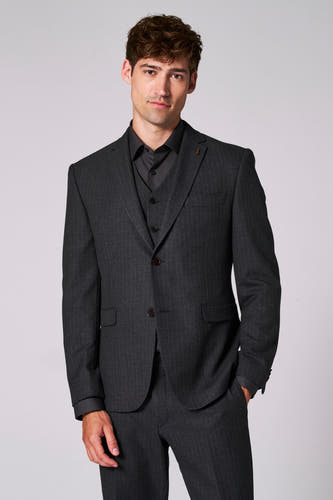 Blazer marron de Le Fabuleux Marcel de Bruxelles, avec un motif de carreaux subtil, porté sur une chemise et un gilet noirs.
