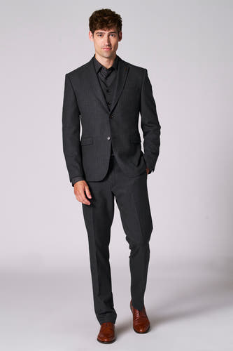 Pantalon de costume brun du Le Fabuleux Marcel de Bruxelles, associé à un manteau gris foncé et des chaussures brunes.
