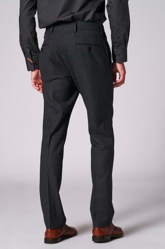 Pantalon de costume marron du Le Fabuleux Marcel de Bruxelles, vu de derrière, avec une structure fine et des chaussures marrons assorties.