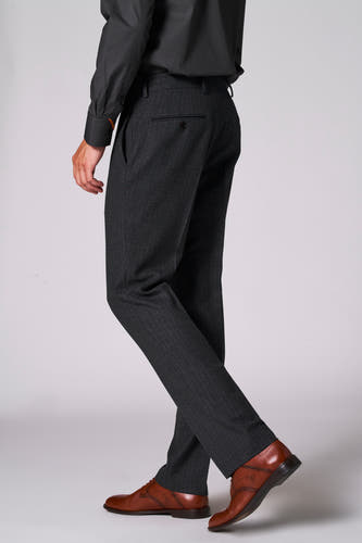 Pantalon de costume brun Le Fabuleux Marcel de Bruxelles, avec une subtile texture en cuir de serpent, associé à des chaussures en cuir brun et un chemisier noir, vue arrière.