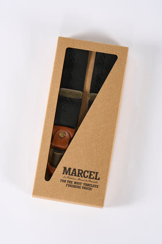 Ceinture noire de Le Fabuleux Marcel de Bruxelles, dans un emballage cartonné marron avec découpe.