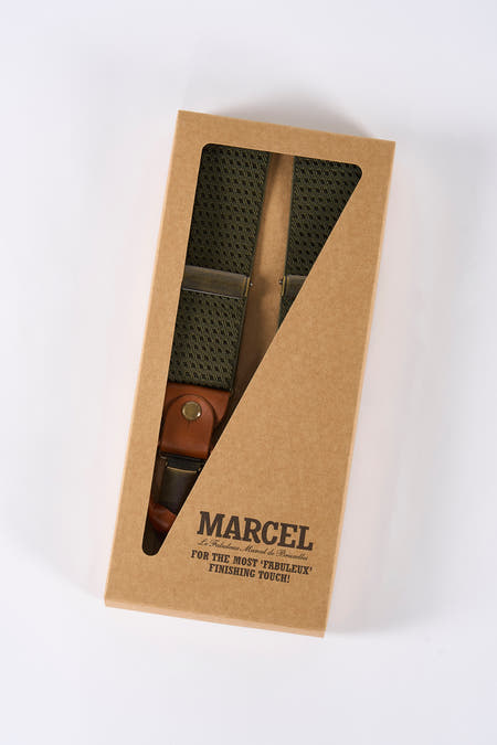 Ceinture verte de Le Fabuleux Marcel de Bruxelles, emballée dans une boîte en carton avec un volet triangulaire.