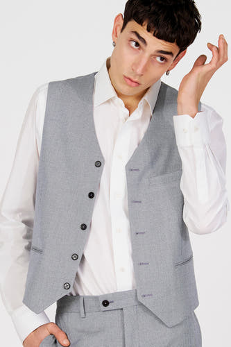 Gilet bleu de Le Fabuleux Marcel de Bruxelles, porté sur une chemise blanche.