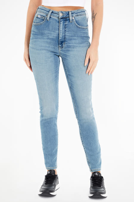 Jean skinny bleu clair de Calvin Klein, avec des poches arrière, associé à des baskets noires.