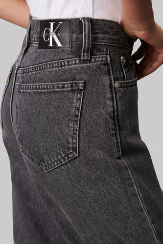 Jean droit gris de Calvin Klein Jeans, avec des surpiqures autour des poches et une étiquette de marque à l'arrière.