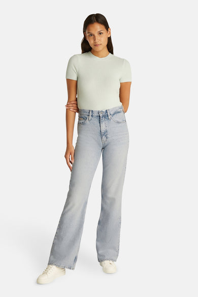 Jean bootcut en denim bleu clair de Calvin Klein, porté avec un t-shirt structuré et des baskets blanches.