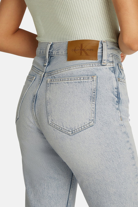 Jean bootcut en denim bleu clair de Calvin Klein, avec une étiquette en cuir de la marque sur la ceinture.
