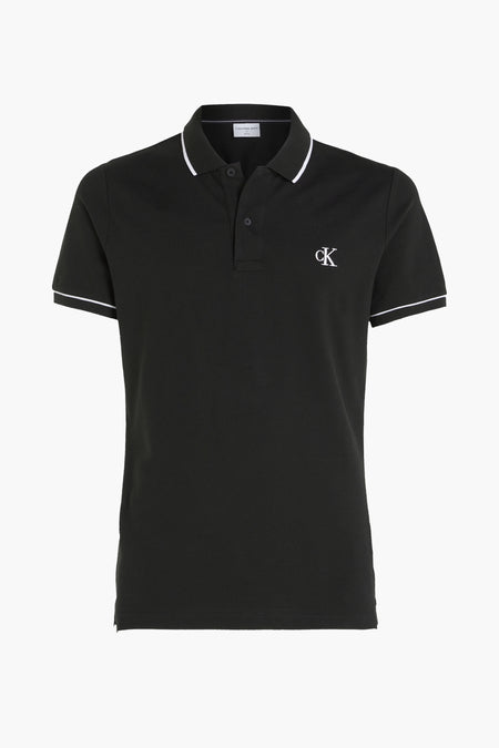 Polo noire Calvin Klein avec un liseré blanc au col et aux manches, et un logo CK sur la poitrine.