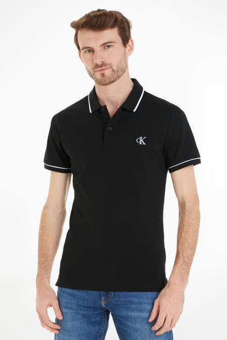 Polo noire Calvin Klein, à manches courtes et avec un passepoil blanc le long du col et des manches.