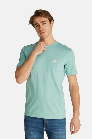 T-shirt turquoise à manches courtes de Calvin Klein, porté avec un jean.