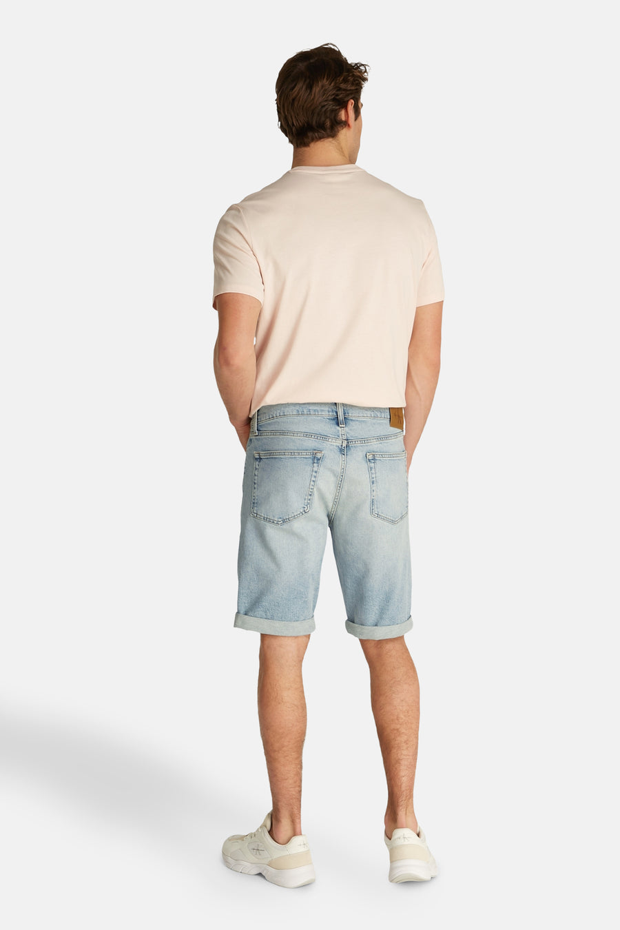 Jeansshort in lichtblauw denim van Calvin Klein, met opgerolde pijpen en verder gecombineerd met een T-shirt.