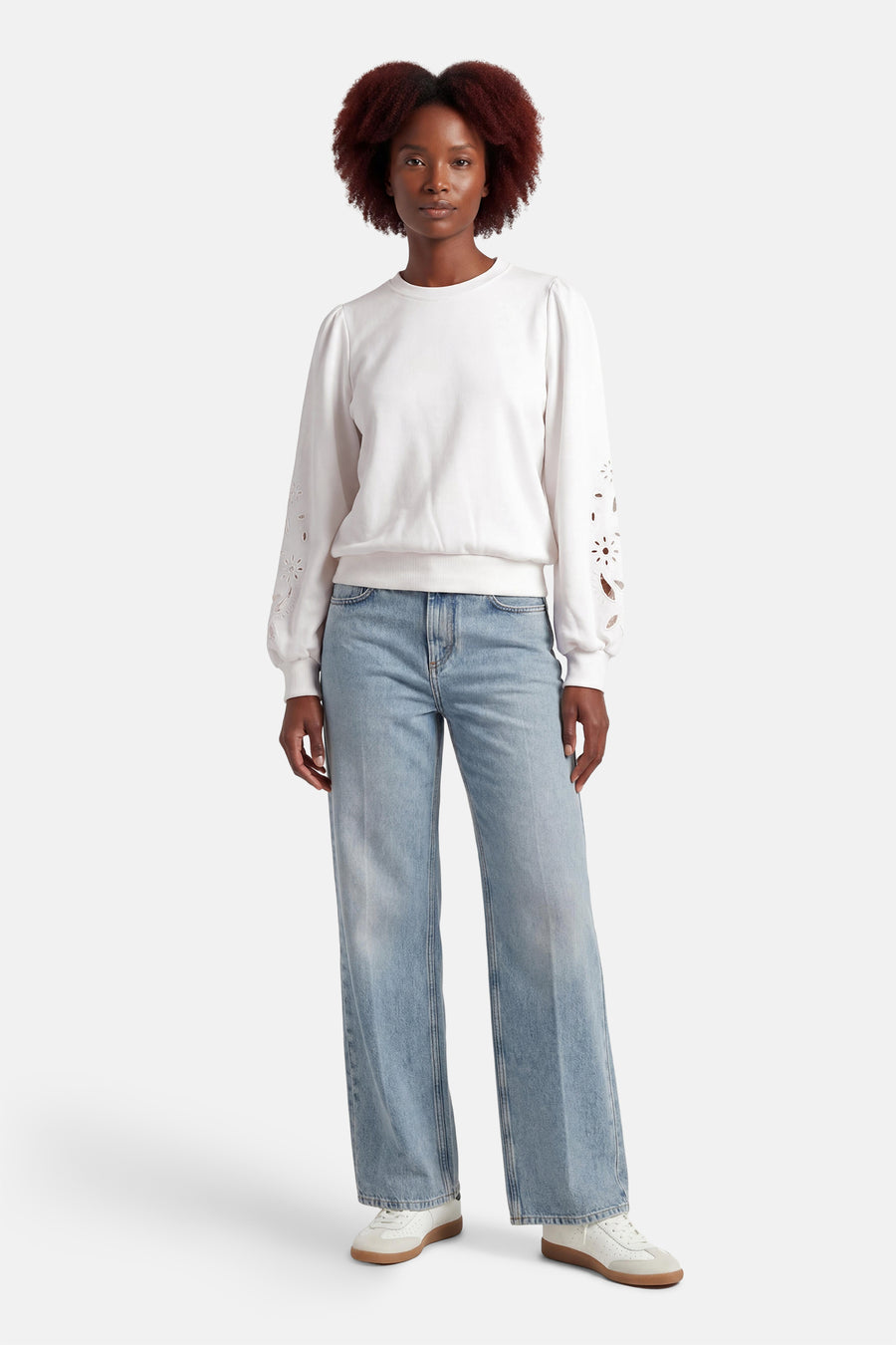 Pull blanc HAILYS, à manches longues avec détails floraux, combiné avec un jean ample et des baskets blanches.