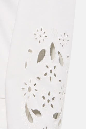 Pull blanc de HAILYS, avec motifs floraux décoratifs et perforations sur la manche.