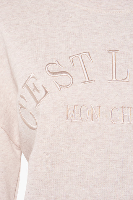 Beige sweater van HAILYS, met geborduurde 'C'est la vie mon cher' tekst.

