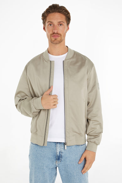 Veste courte écru de Calvin Klein avec un tissu finement tissé et une étiquette de marque rectangulaire en relief.