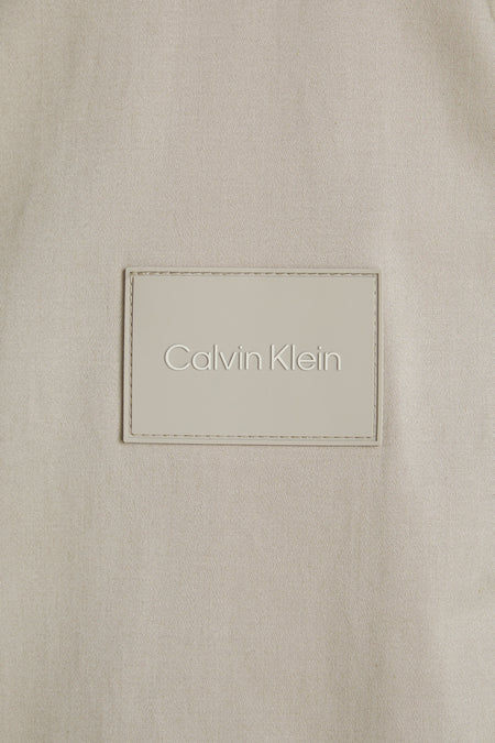 Ecru korte jas van Calvin Klein met fijn geweven stof en een rechthoekige, reliëfmerklap.