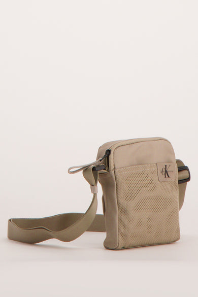 Sac à dos brun de Calvin Klein Jeans, avec des détails en mesh sur les côtés et une sangle ajustable.