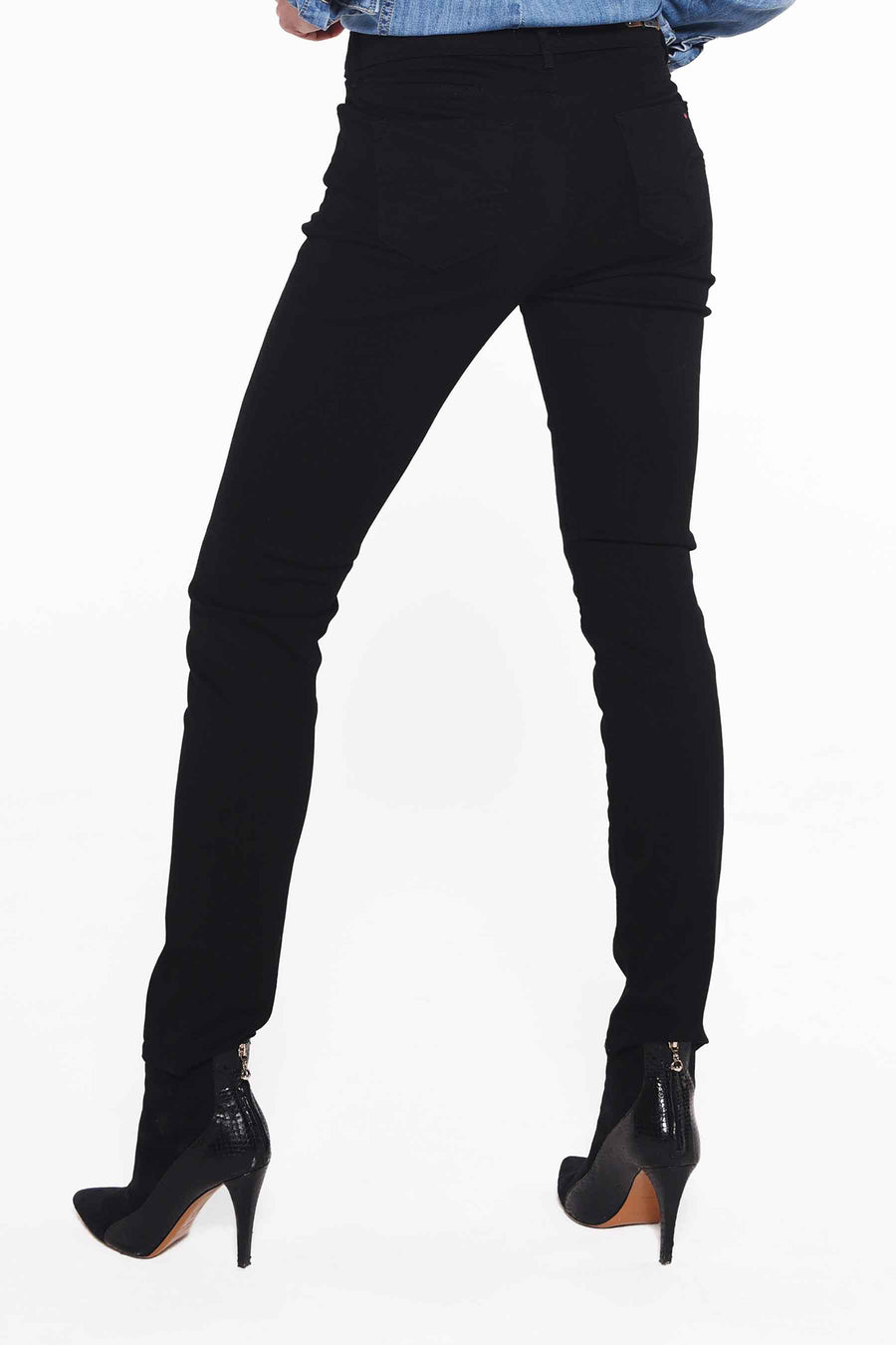 Jean slim fit noir de Lee Cooper, avec des coutures droites et porté avec des bottes noires.