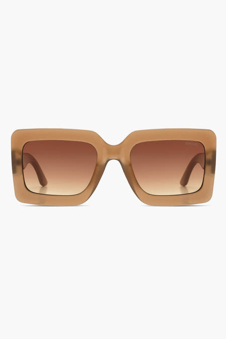 Lunettes de soleil beige de Komono, avec des verres bruns et un cadre anguleux.
