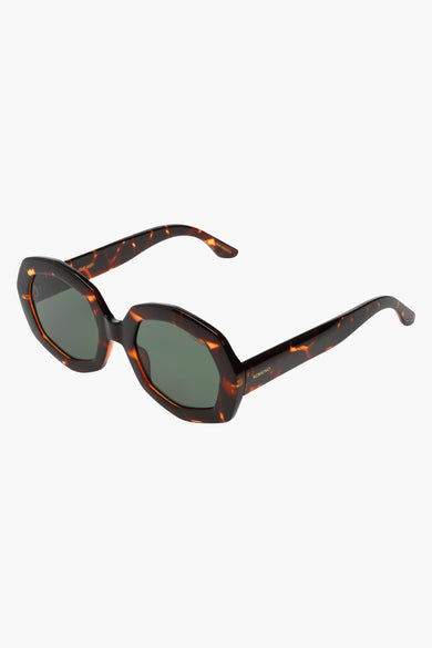 Lunettes de soleil brunes de KOMONO avec un motif tortue et des verres foncés, en gros plan.
