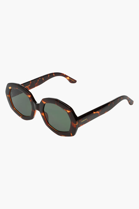 Lunettes de soleil brunes de KOMONO avec un motif tortue et des verres foncés, en gros plan.