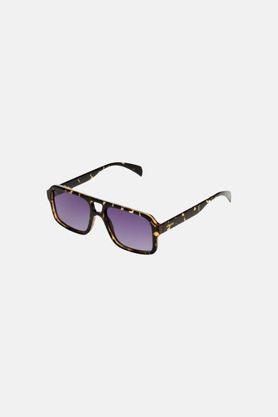 Lunettes de soleil vertes de KOMONO, avec une monture écaille de tortue et des verres violets.