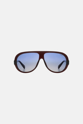 Lunettes rouge-brun de KOMONO avec verres à dégradé bleu et logo.