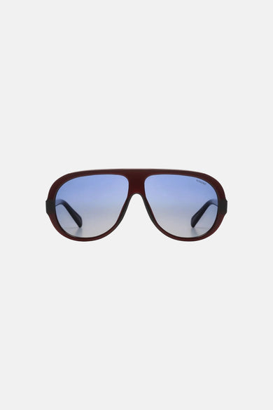 Lunettes rouge-brun de KOMONO avec verres à dégradé bleu et logo.
