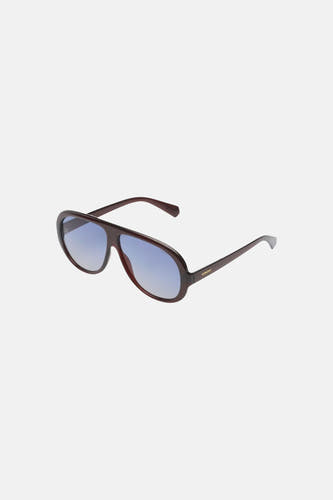 Lunettes marron foncé de KOMONO avec verres à dégradé bleu, présentées de biais de face.