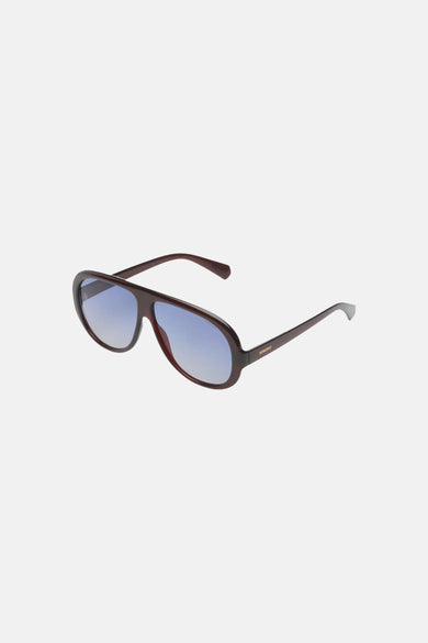 Lunettes marron foncé de KOMONO avec verres à dégradé bleu, présentées de biais de face.