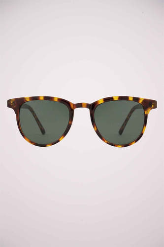 Lunettes de soleil vertes de KOMONO, avec un cadre en motif de tortue brune et des verres foncés.