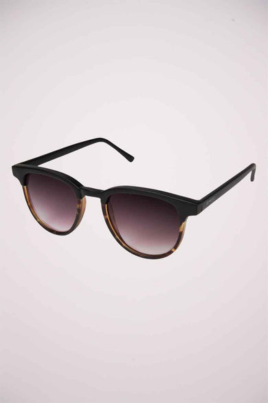 Lunettes de soleil noires KOMONO, avec un motif de tortue à la base du monture et des verres teintés foncés.