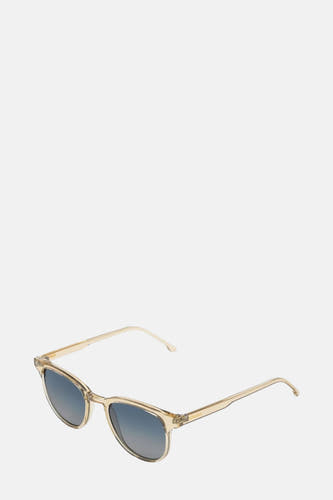 Lunettes de soleil bleues de KOMONO, avec un cadre transparent et des verres arrondis.