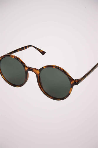 Lunettes de soleil vertes de KOMONO, avec un cadre en tortue brune.