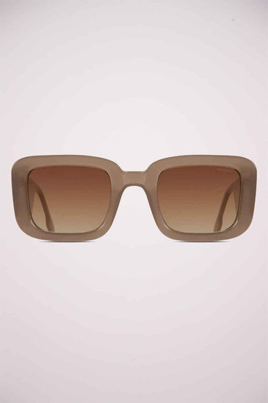 Lunettes de soleil beige de KOMONO, avec des verres carrés et une transition de couleur marron.