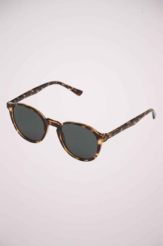 Lunettes de soleil vertes de KOMONO avec un motif de tortue sur le monture et les branches.