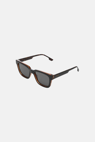 Lunettes de soleil noires KOMONO avec un détail de monture marron et des verres sombres.