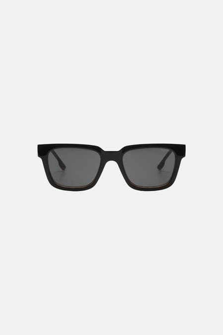 Lunettes de soleil noires KOMONO, avec une monture rectangulaire et des verres foncés.