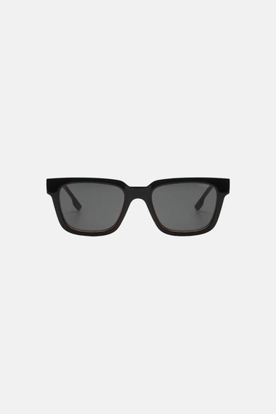 Lunettes de soleil noires KOMONO, avec une monture rectangulaire et des verres foncés.