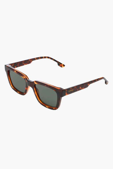 Lunettes de soleil marron de KOMONO, avec un motif de tortue sur la monture et les branches.