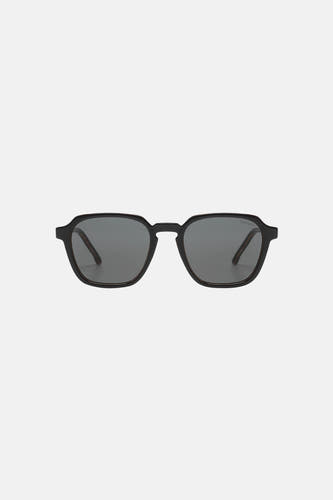 Lunettes de soleil noires de KOMONO, avec une monture minimaliste et des verres foncés.