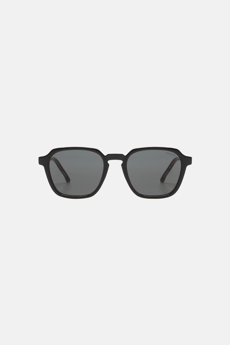 Lunettes de soleil noires de KOMONO, avec une monture minimaliste et des verres foncés.