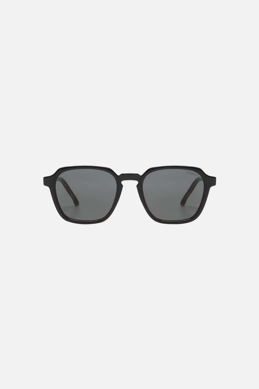 Lunettes de soleil noires de KOMONO, avec une monture minimaliste et des verres foncés.