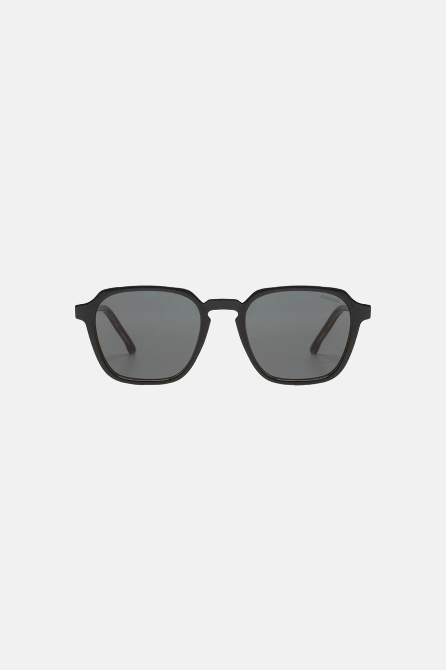 Lunettes de soleil noires KOMONO avec verres gris foncé et une monture subtilement angulaire.