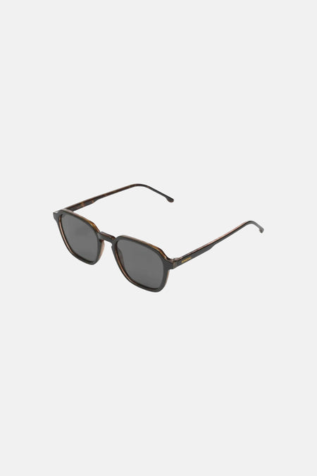 Lunettes de soleil noires KOMONO avec verres teintés et une monture géométrique écaille de tortue.