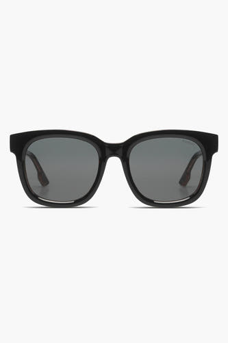 Lunettes de soleil noires KOMONO, avec un cadre brillant et des verres sombres.