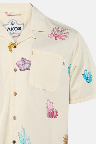 Chemise de couleur crème à manches courtes de LAKOR, avec un imprimé multicolore de coraux et de cristaux, des boutons effet bois et une poche poitrine.