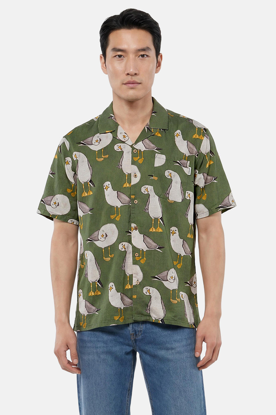 Chemise verte à manches courtes de LAKOR, avec imprimé mouettes, portée par un homme en jean.